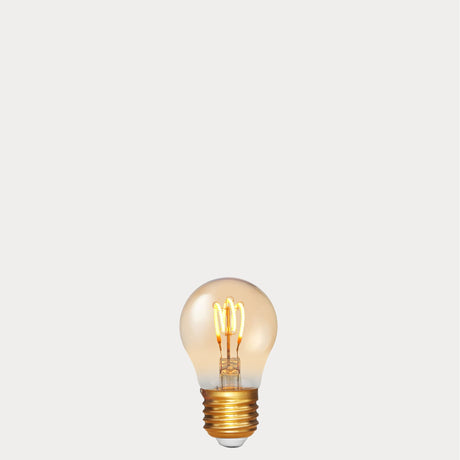 Dulora 4W Vintage Fancy Round LED Bulb E27 in Ultra Warm White glowing with deep amber warmth through tinted glass