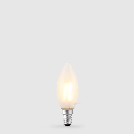 The Liquid LEDs 4W 24 Volt DC Candle LED Bulb E14 Frost in Warm White glows softly with a dimmable, frosted finish against a light gray background.