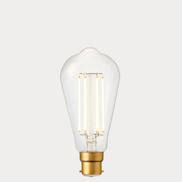 Dulora 4.2W Edison LED Bulb B22 in Extra Warm White illuminated showing warm amber glow through clear ST64 glass