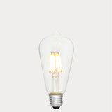 Dulora 8W E27 LED Edison-style bulb in clear glass with AC/DC compatibility, glowing with 2700K warm white light.